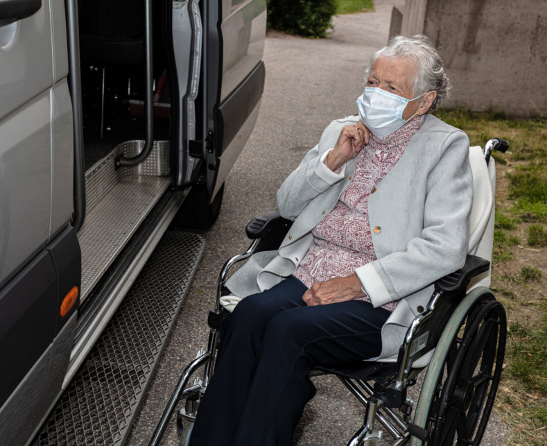 elderly woman in wheelchair beside the car