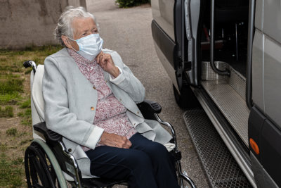 elderly woman preparing to board on a van